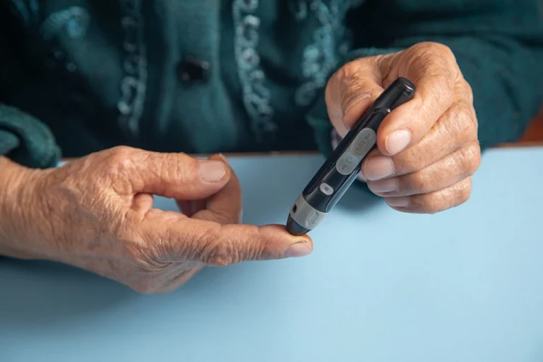 Eine Person, die mit einem Stift den Blutzuckerspiegel überprüft